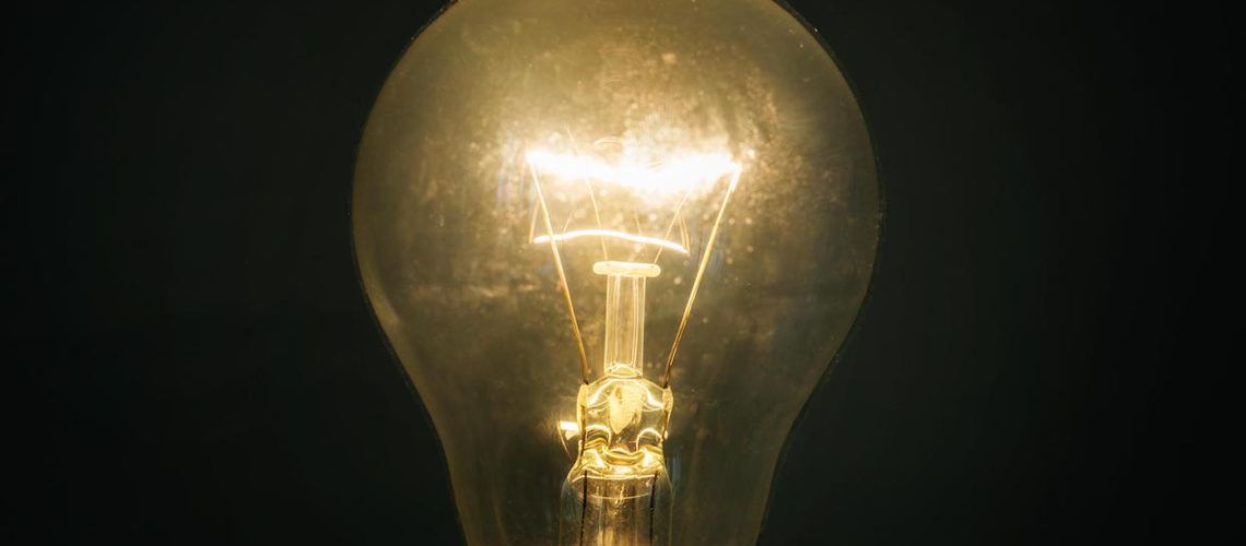 Glowing glass light bulb on dark background