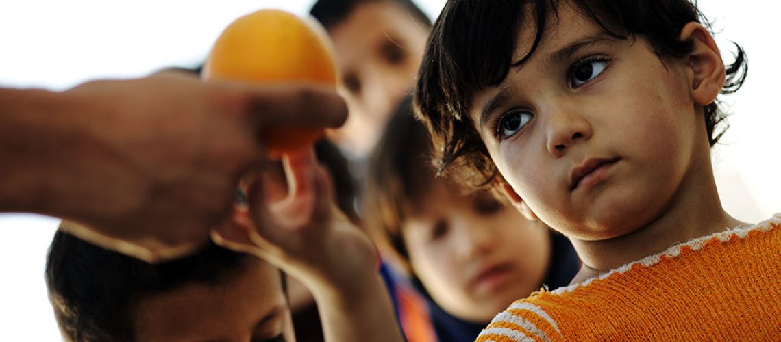 Hungry children in refugee camp, distribution of humanitarian food